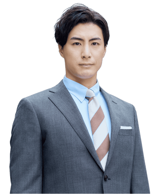 グレーのスーツ、水色のシャツ、ストライプのネクタイを着用した男性が、無表情で正面を向いて立っており、無地の背景にIT戦略パートナーとしてのプロフェッショナルなイメージをアピールしています。